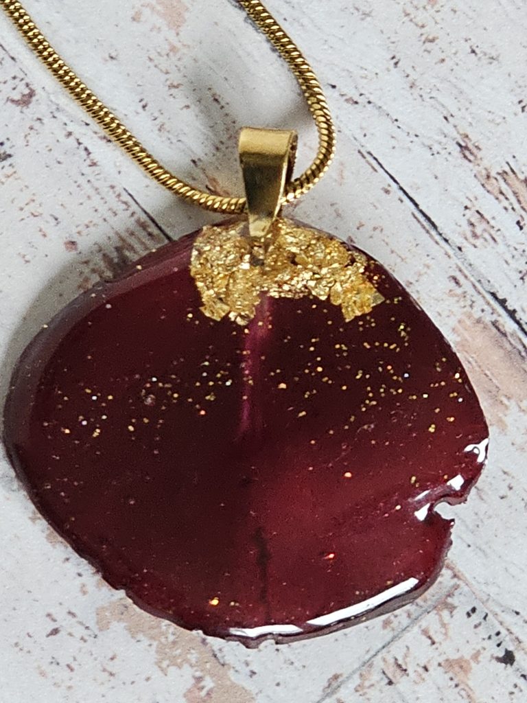 Single rose petal hand made pendant on stainless steel chain on white washed floor