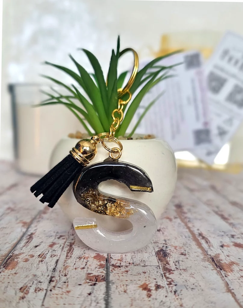Hand poured black and white with gold flakes 'S' resin keyrings with black tassel on gold tone keyring chain.
