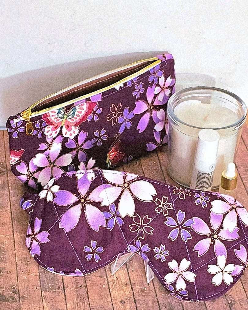 Matching sleep mask and toiletries bag made with gold foiled flowers on deep purple fabric. 